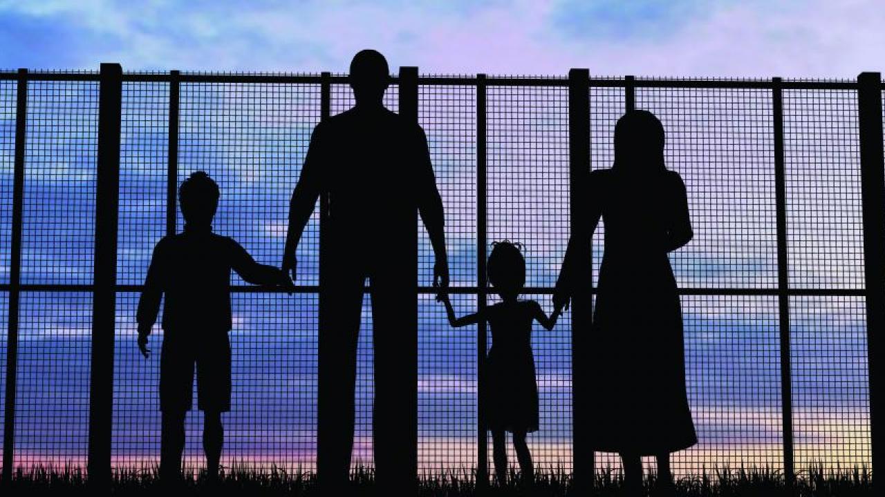 Silhouette of a family at a fence