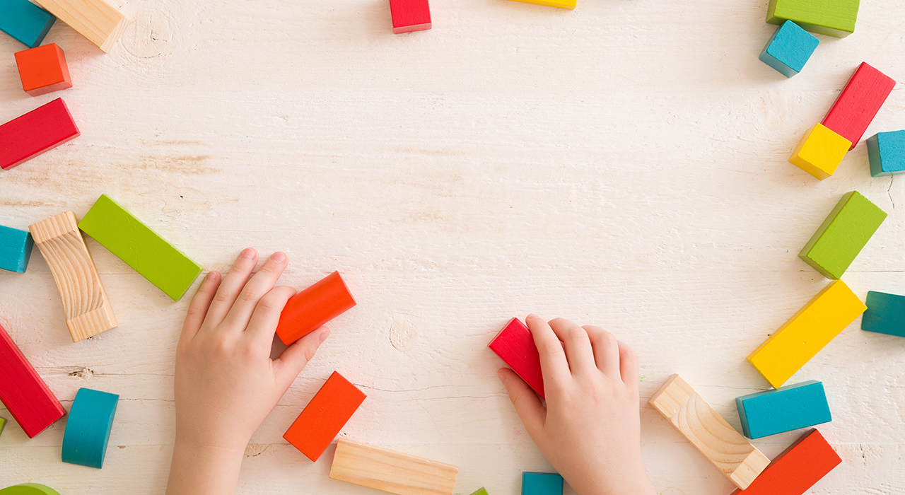 Colorful blocks in a circle being handled by two hands