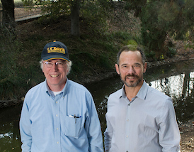 Jay Lund and Nicholas Pinter posing in front of water at UC Davis Arboretum