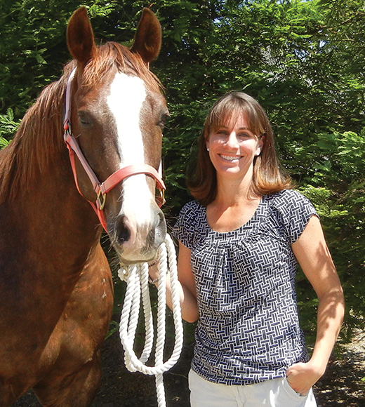 Carrie Finno standing with horse