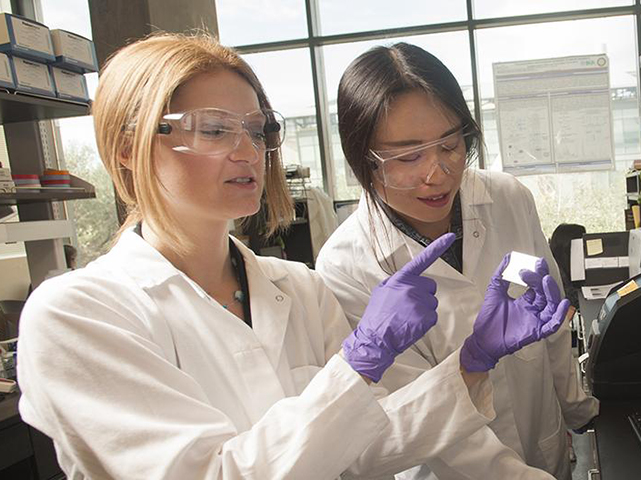 Two people examining a slide in a lab