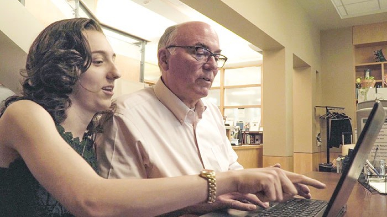 Zoe Eiselt and her dad, Kurt Eiselt, at the MIND Institute Resource Library Father and daughter sitting in front of a laptop.