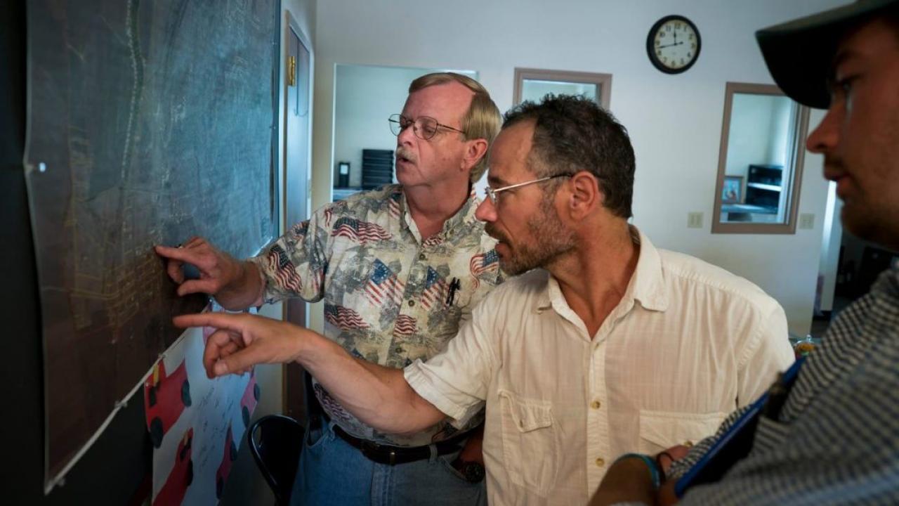 Dennis Knobloch, Nicholas Pinter and James “Huck” Rees look at a map of Valmeyer in the village offices.
