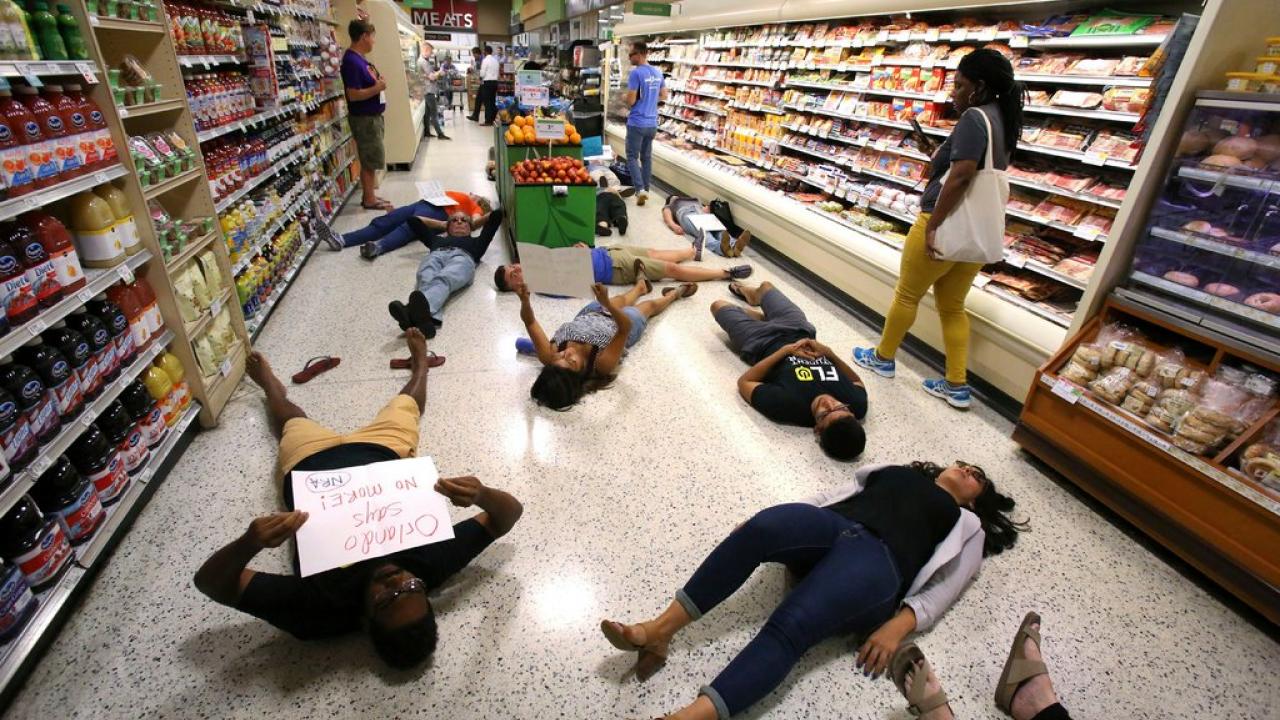 Demonstrators against gun violence lying on the floor of a supermarket in Orlando, Fla., last year.
