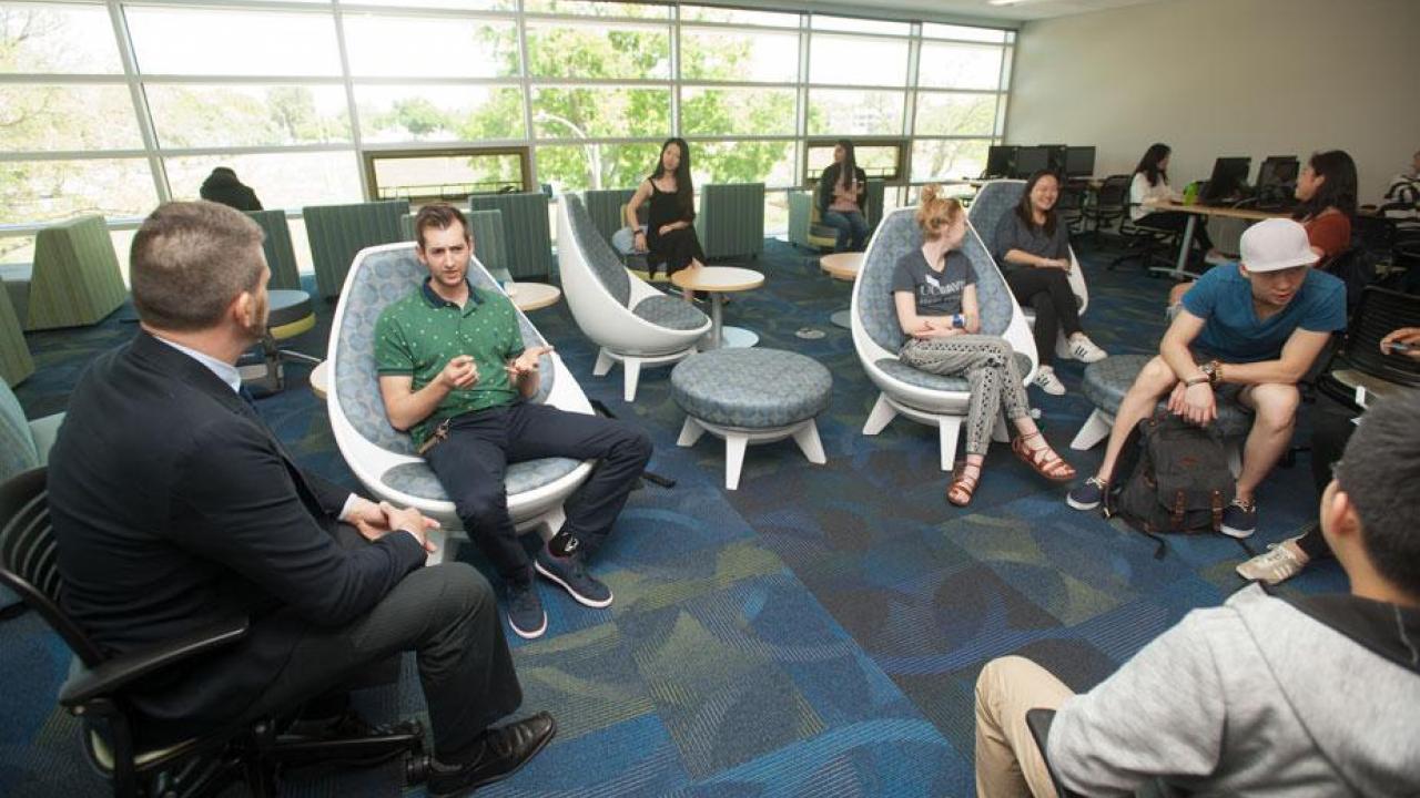 Students and vistors sitting at the UC Davis International Center main lobby area. 