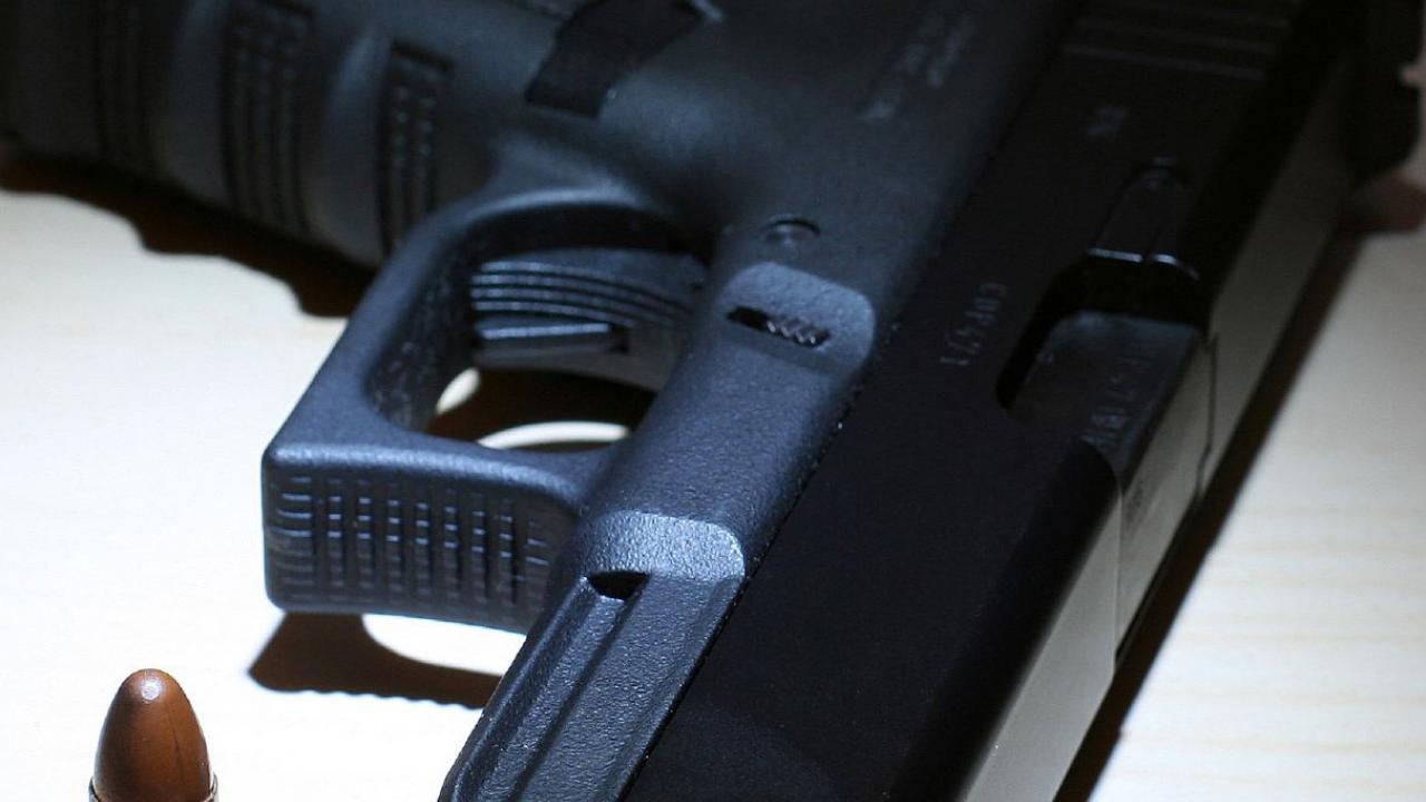 Close up image of a handgun and bullet