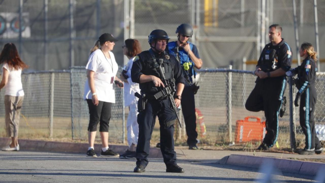 A police officer stands guard outside Gilroy High School soon after a gunman killed three people on July 28 at the nearby Gilroy Garlic Festival in Northern California.(Nhat V. Meyer / Associated Press)