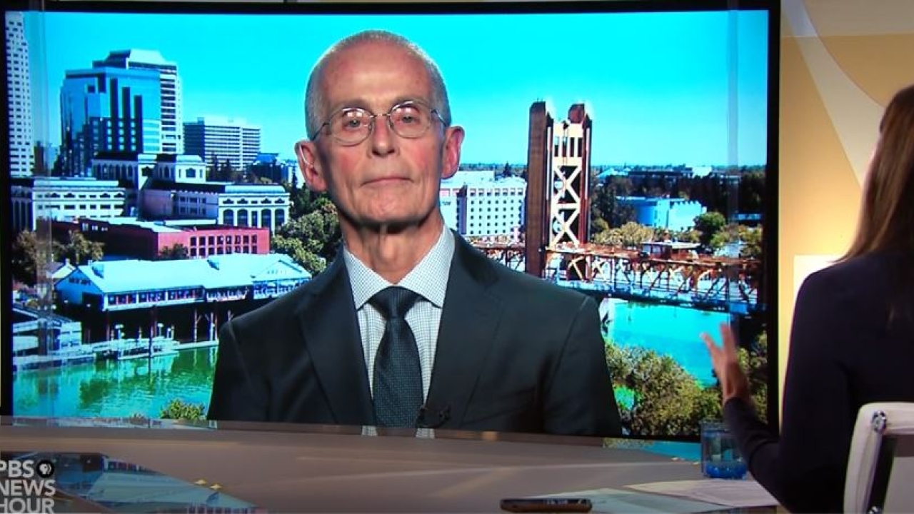 Garen Wintemute in front of a photo of downtown Sacramento