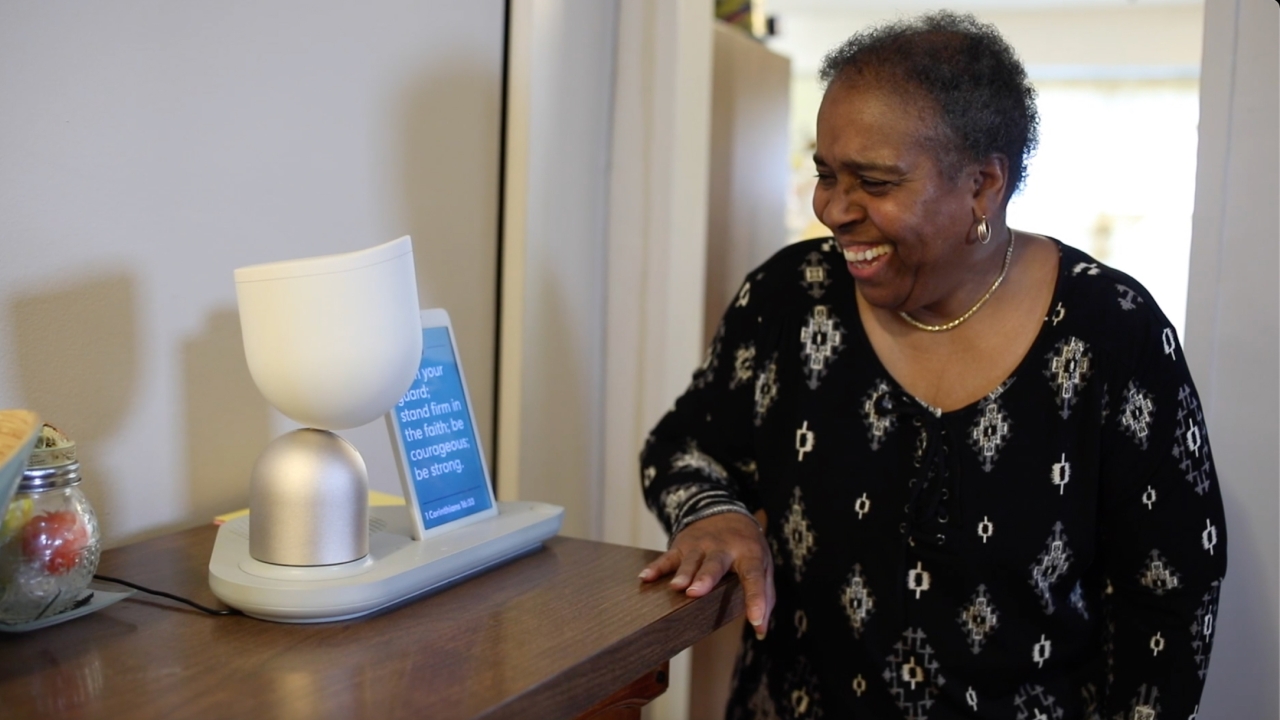 A patient uses an interactive robot and display placed on a wooden desk.