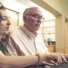 Father and daughter sitting in front of a laptop.