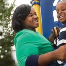 Young mother and son smiling at a playground.