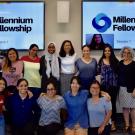 Group of students in front of TV screens that say Millennium Fellowship. 
