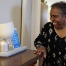 A patient uses an interactive robot and display placed on a wooden desk.